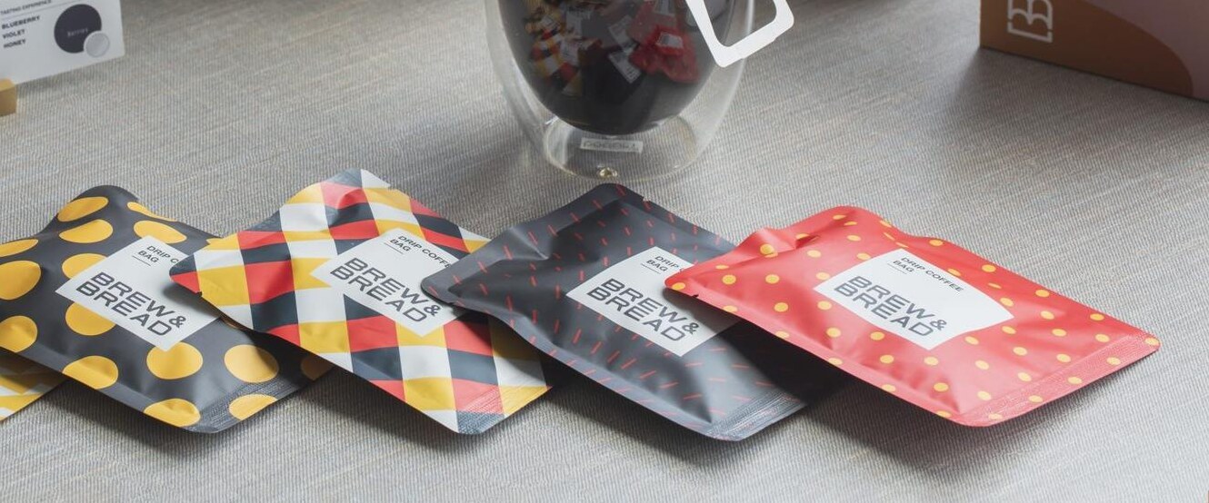 Three-side-sealed coffee sachets fanned out on a linen table
