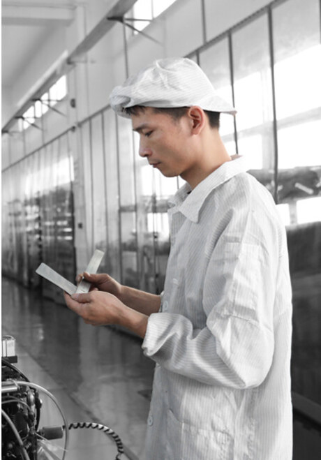 Quality inspector measuring a printed film sample against the specification sheet
