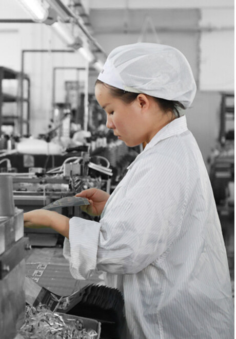 Operator inspecting laminated film for colour and registration at the slitting station
